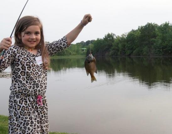 Little girl holding a fish she caught.